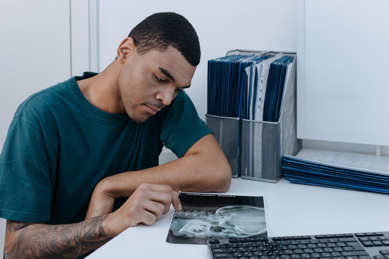 Crafting Captivating Headlines: Your awesome post title goes here A man examines a dental X-ray at a clinic table, focusing intently on the image.